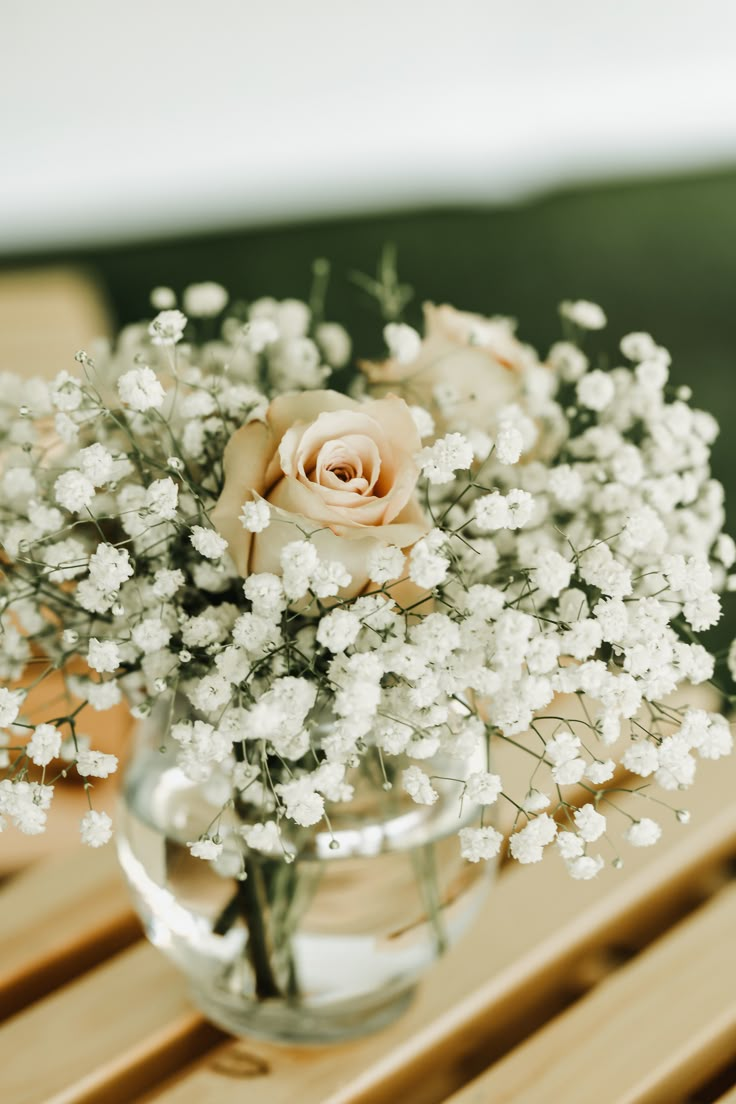 a vase filled with white flowers on top of a wooden table