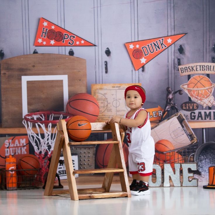 a young boy standing next to a ladder in front of basketball themed wallpapers