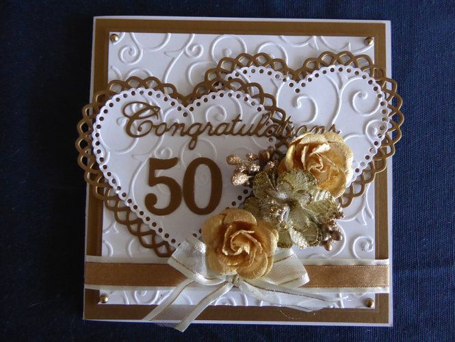 a close up of a greeting card with flowers and a heart on the front that says congratulations 50