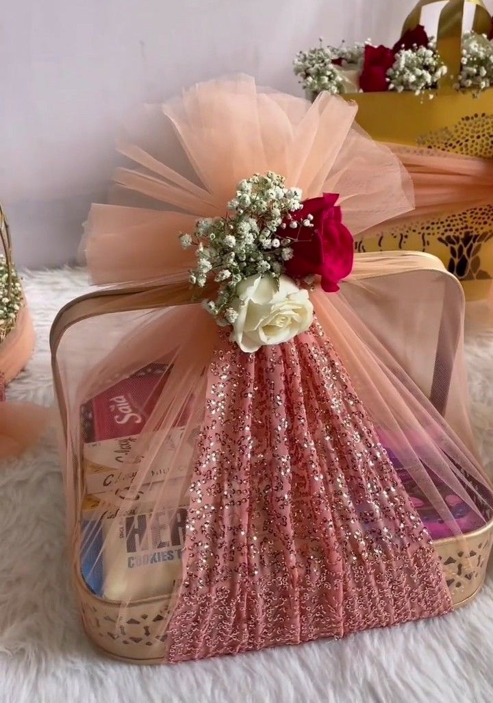 a pink purse with flowers in it sitting on top of a white furnishing