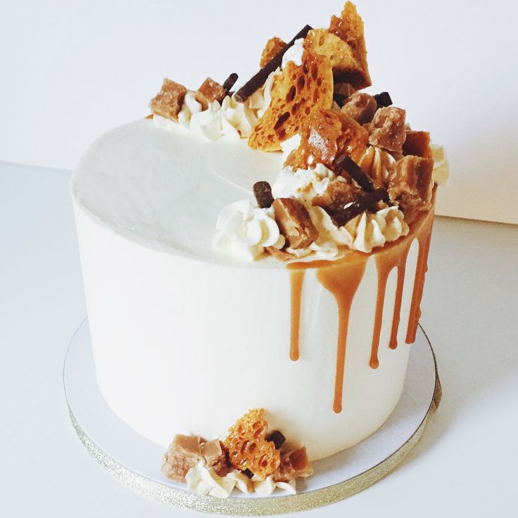 a cake with white frosting and caramel drizzled on the top