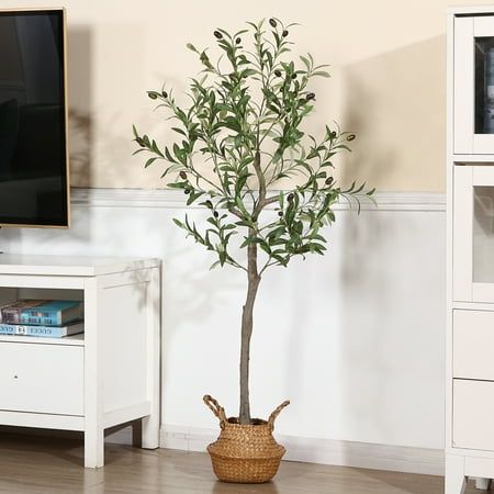 a small tree in a basket next to a flat screen tv on a white entertainment center