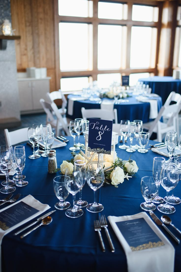 the table is set with wine glasses and place settings