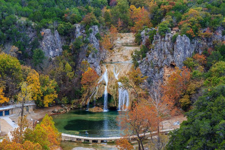 an aerial view of a waterfall surrounded by trees