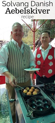 two men in aprons cooking food on an outdoor grill