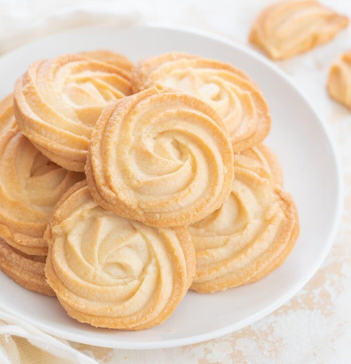 a white plate filled with cookies on top of a table next to some napkins