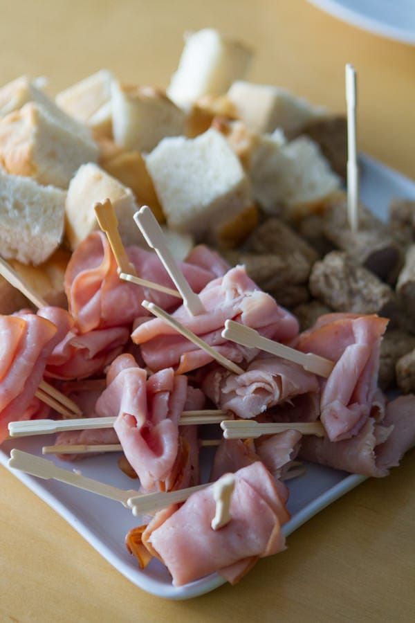 meat and bread skewers on a plate with toothpicks sticking out of them