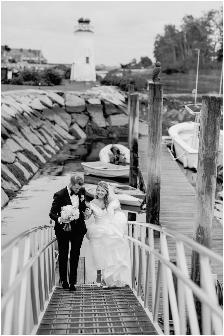 the bride and groom are walking down the dock