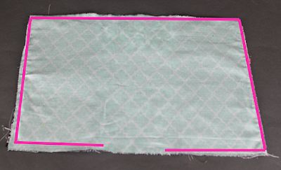 a piece of cloth with pink trim on it sitting on top of a black surface