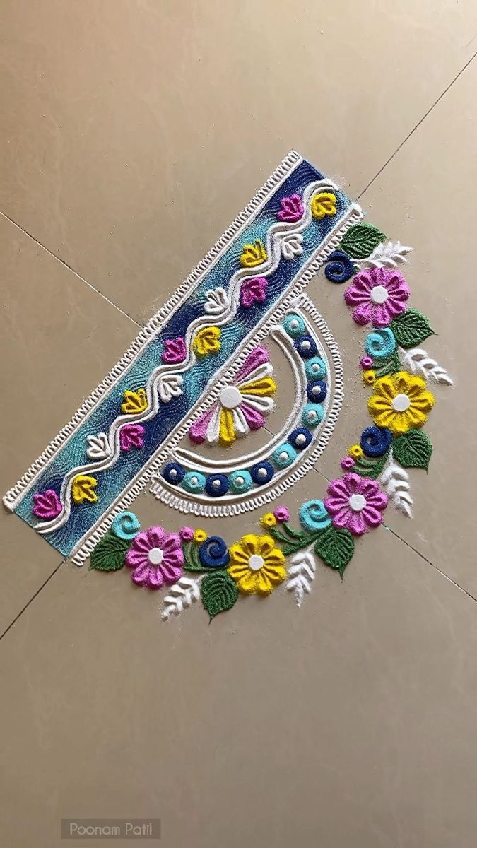 an intricately decorated design on the floor with flowers and leaves in blue, pink, yellow and green colors