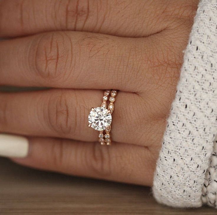 a woman's hand with two rings on it