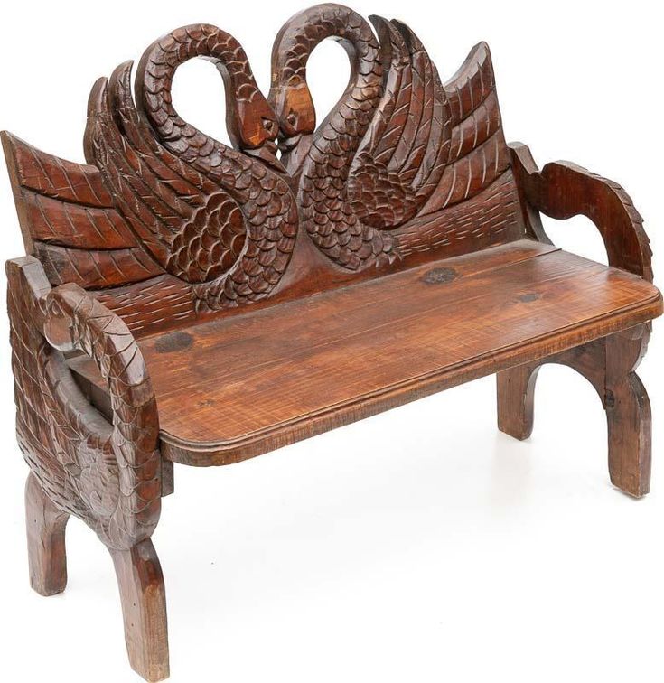 a wooden bench with two carved swans on it