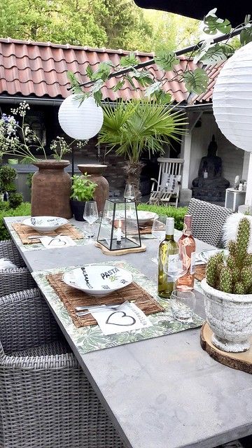 an outdoor dining area with table, chairs and potted plants