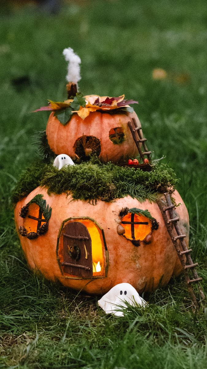 a pumpkin shaped house is sitting in the grass