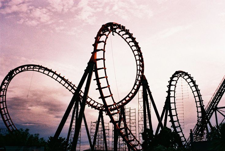 an amusement park roller coaster at dusk