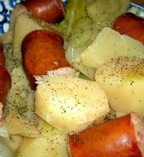 a close up of a plate of food with sausages and potatoes