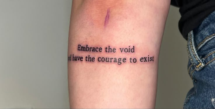 a person with a tattoo on their arm that says embrace the void have the courage to exit