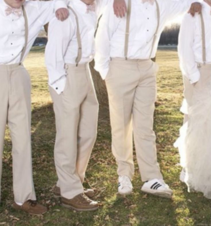 four young men dressed in formal wear posing for a photo together with their arms around each other