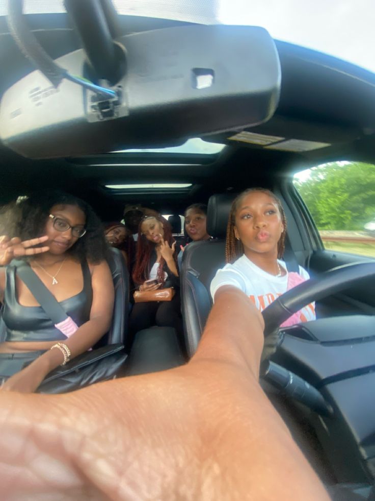 two women sitting in the passenger seat of a car