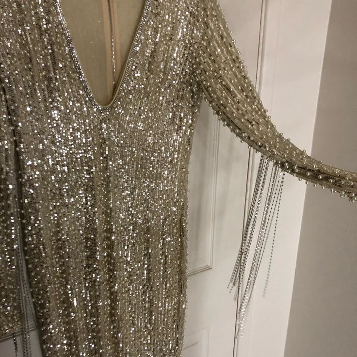 This Is A Brand New Dress, Only Tried On Once And Turned Out To Be Too Big For Me. I Ordered A Second A Size Smaller For My Bachelorette Party And Received Non Stop Compliments On This Dress Plunging V Neck Rhinestone Dress. Silver Sequins And Pearls. Silver Chain Tassels Run Down The Arms And Are Mostly Focused Around The Elbows. Lining Is A Sheer Nude Stretchy Nylon. Top Layer Is Also Pretty Stretchy. Will Probably Fit Up To A 2x. This Dress Is Size L (I Wore A Medium And Probably Could Have G Party Season Long Sleeve Dress With Rhinestone Fringe, V-neck Dresses With Rhinestones For Party Season, Long Sleeve Evening Dress With Rhinestone Fringe, Glamorous Long Sleeve Dress With Rhinestone Fringe, Elegant White Dress With Rhinestone Fringe, Cocktail Dresses With Rhinestones And V-neck, Elegant Silver Mini Dress With Rhinestone Fringe, Silver Mini-length Dresses With Rhinestones, Elegant V-neck Dress With Rhinestone Fringe