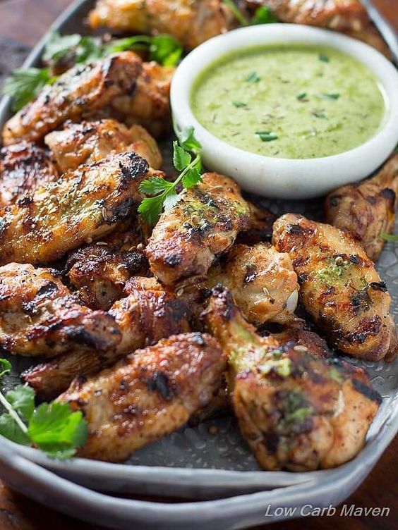 grilled chicken wings on a platter with dipping sauce