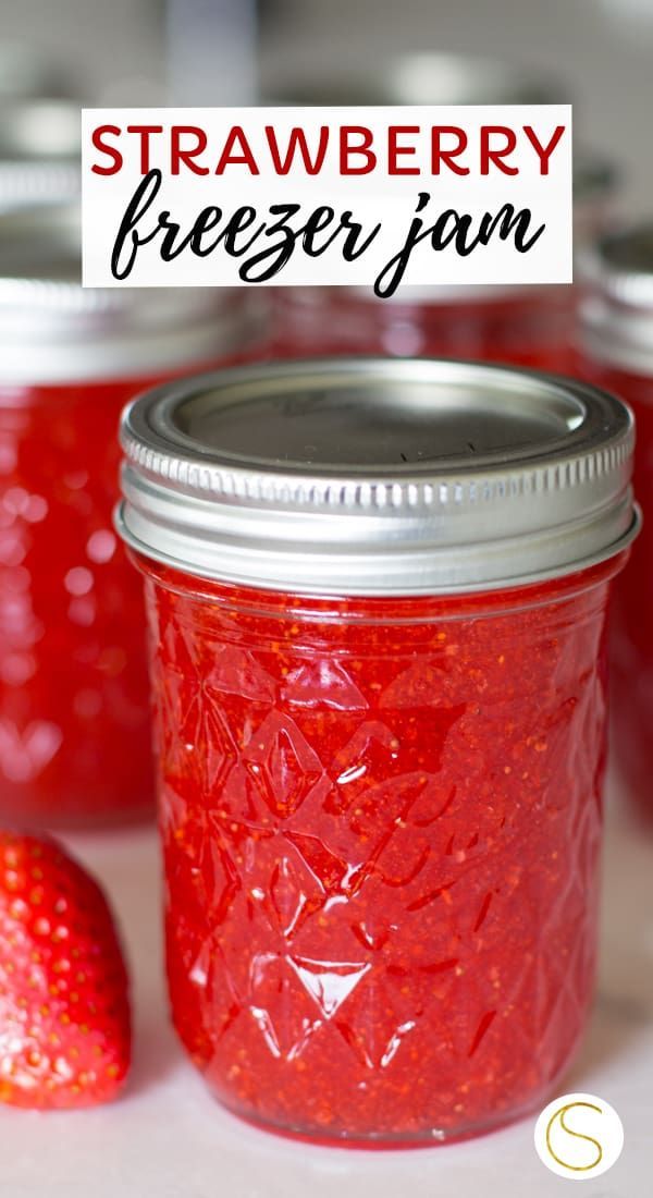 strawberry freezer jam in a mason jar with strawberries