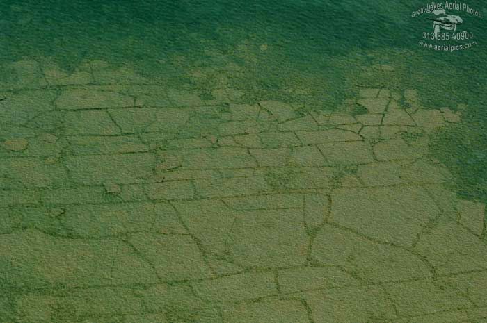 an aerial view of green grass and rocks