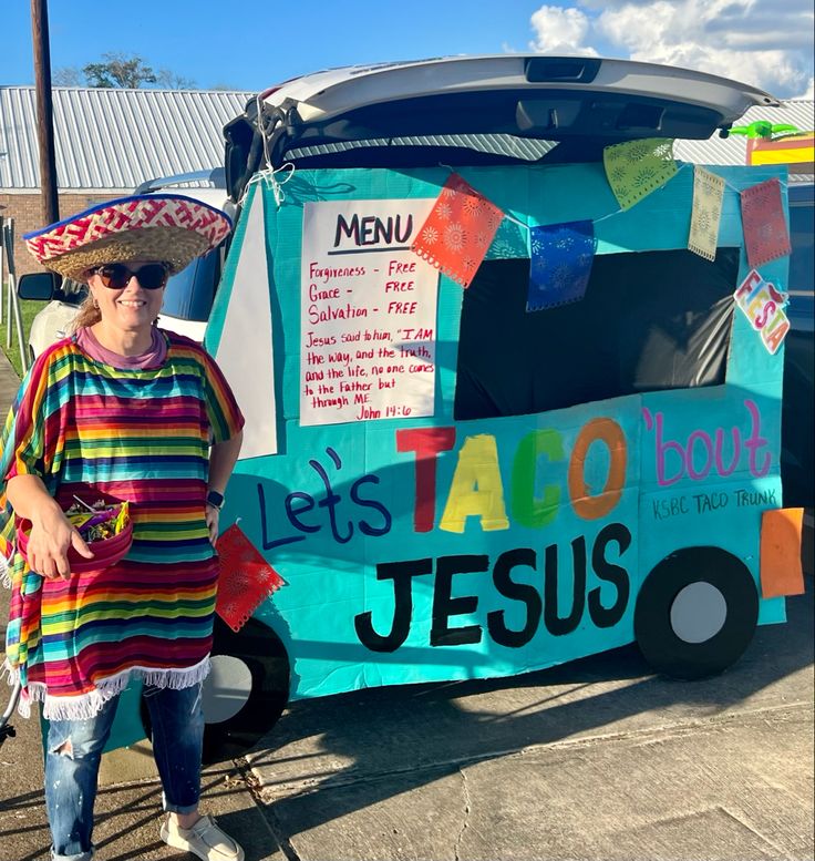 a woman wearing a sombrero standing in front of a food truck that sells tacos