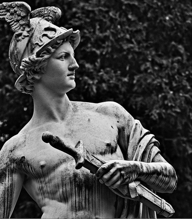 black and white photograph of a statue holding a pair of scissors