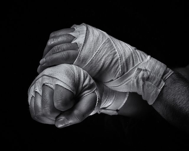 a hand with bandages wrapped around it's thumb in the dark, black and white photo