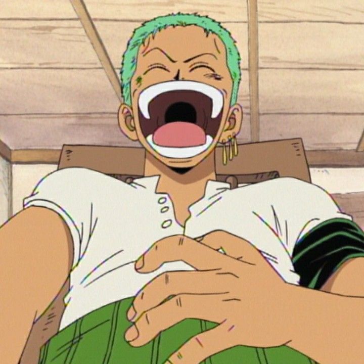 a man with green hair is laughing and holding his hands out in front of him