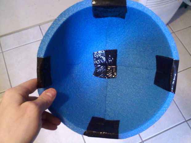 a person holding up a blue object with black squares on it