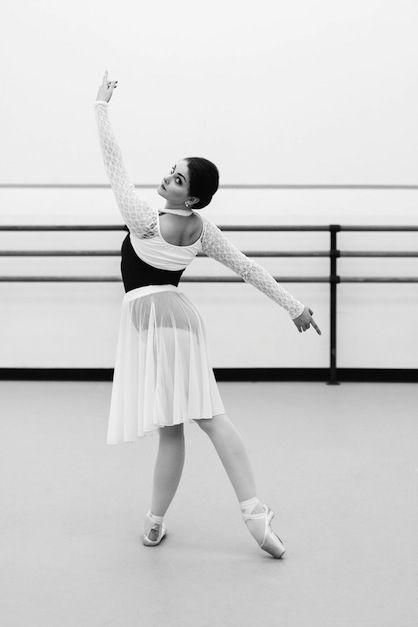 a black and white photo of a woman in a ballet outfit with her arms outstretched