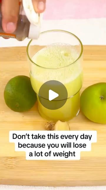 a person is cutting limes with a knife on a cutting board next to two green apples