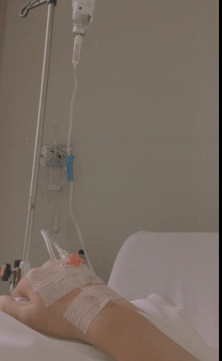 a person laying in a hospital bed with an iv drip attached to their arm