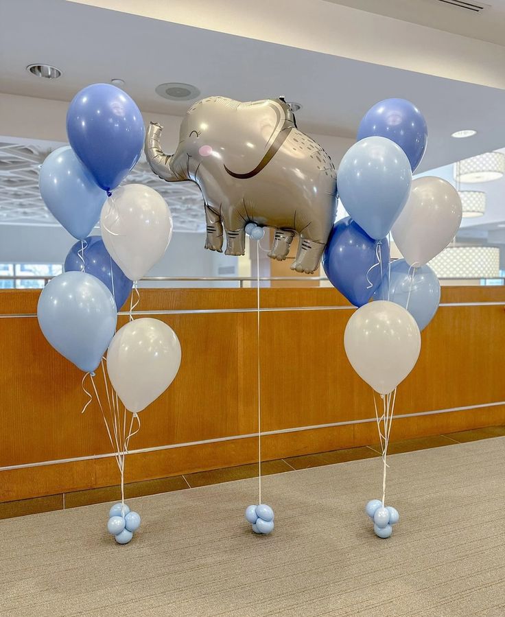 some balloons are in the shape of an elephant and one balloon is attached to a wall