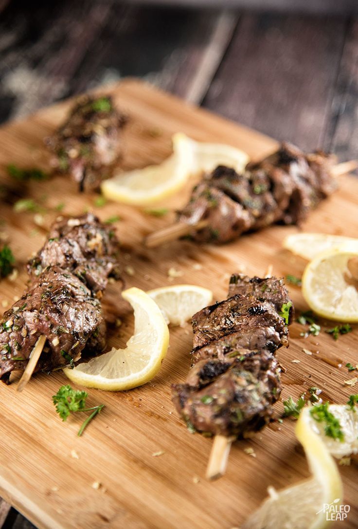 some meat and lemons on a wooden cutting board