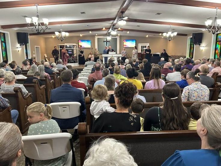 a large group of people are sitting in chairs