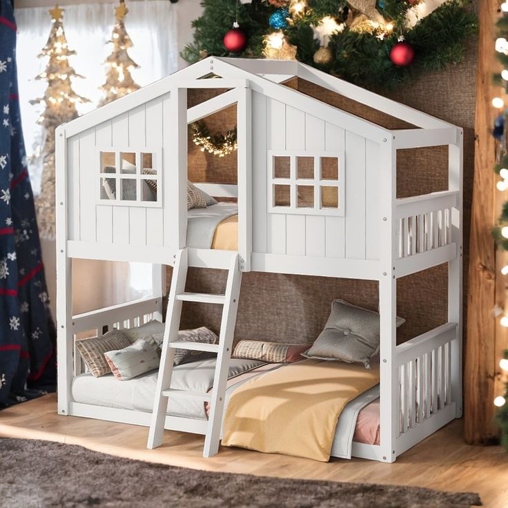 there is a white bunk bed with stairs to the top and below it, in front of a christmas tree