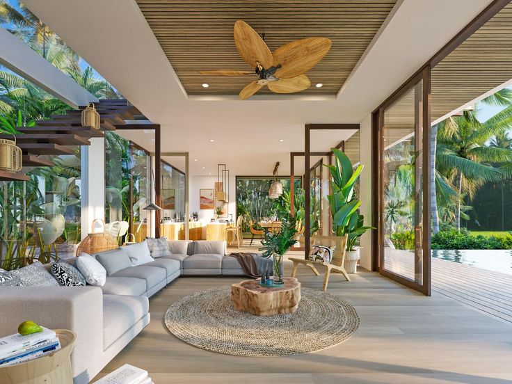 a living room filled with furniture next to a large window covered in plants and palm trees