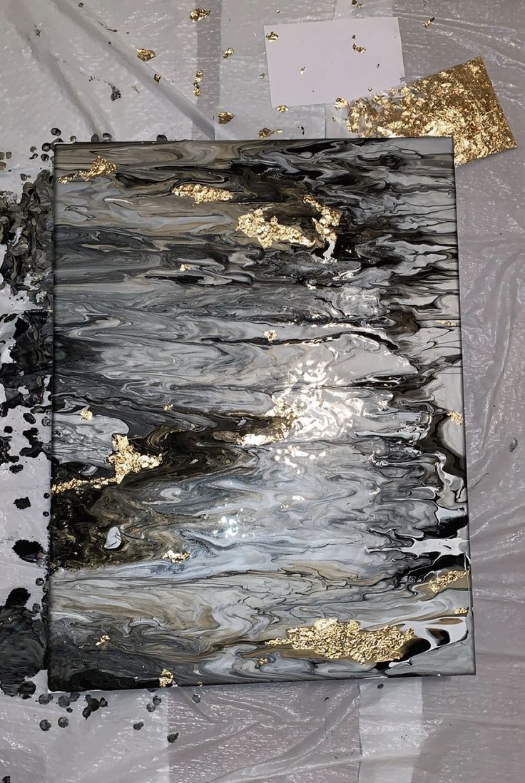 an abstract painting with gold and black paint