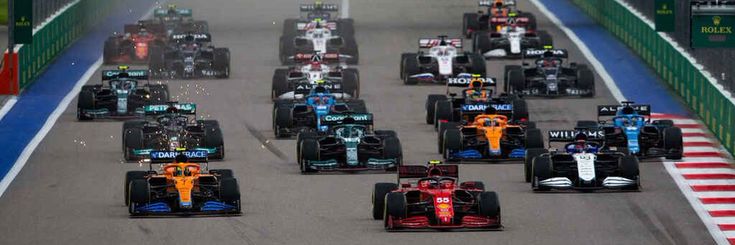 a group of racing cars driving down a race track in the middle of a tunnel