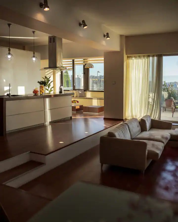 a living room filled with furniture next to a large glass window overlooking the cityscape