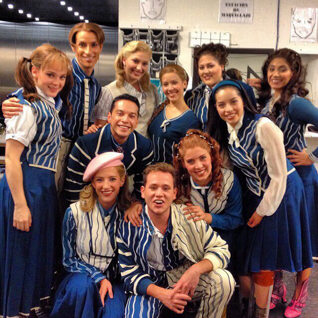 a group of people in blue and white outfits posing for a photo with one another