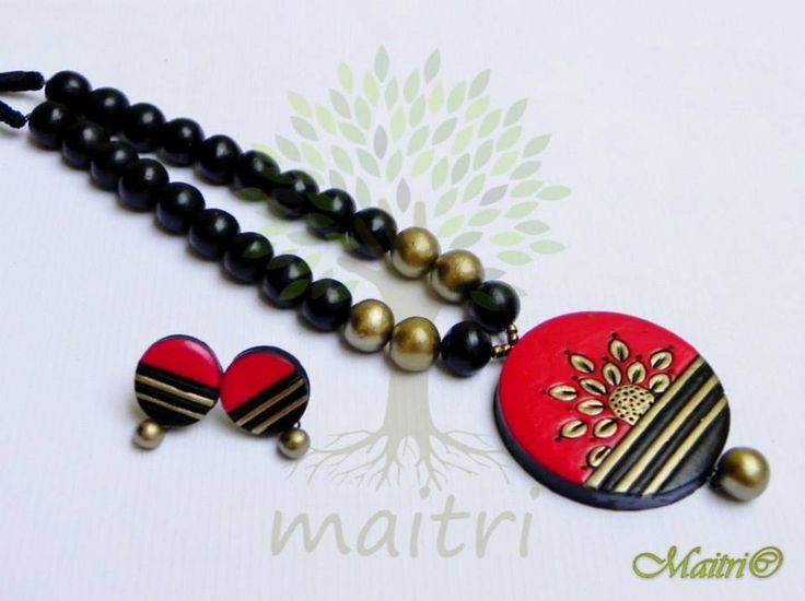 the necklace is decorated with black and red beads, heart shaped pendants, and two matching earrings