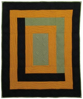 a black and yellow quilted wall hanging on a white wall with an orange square in the center