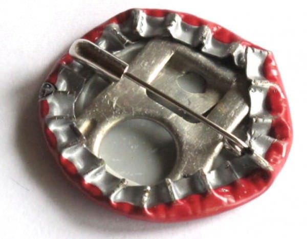 a red and silver metal object on a white surface