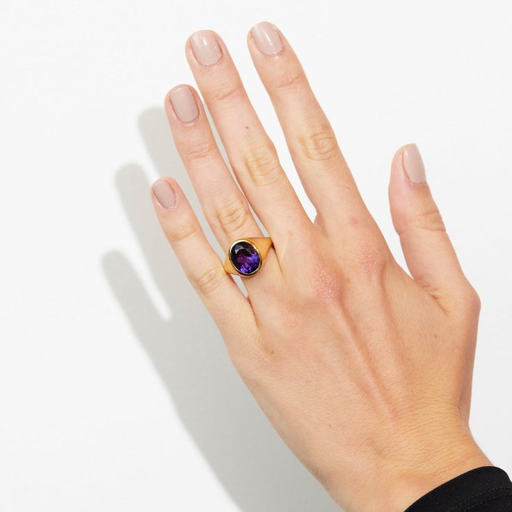 Take your style to a higher level with the magnificent Aphrodite statement ring featuring an oval amethyst made with Fairmined 18k yellow gold by Chroma. • Fairmined 14k yellow gold • 4.90ct Oval Amethyst • Band Width: 2mm - 6mm • In stock in size 6. This ring is able to be resized, please allow 4 weeks. Designed and crafted by us in NYC using recycled gold, conflict-free diamonds and responsibly sourced gemstones. The Fairmined program certifies gold created by small scale mining organizations, Luxury Yellow Gold Amethyst Ring Oval Cabochon, Elegant Purple Amethyst Signet Ring, Modern Gold Amethyst Gemstone Ring, Elegant Amethyst Signet Ring For Formal Occasions, Elegant Formal Amethyst Signet Ring, Purple Elegant Signet Ring For Formal Occasions, Modern Gold Amethyst Ring With Oval Shape, Modern Oval Amethyst Ring With Polished Finish, Luxury Purple Amethyst Oval Cabochon Ring