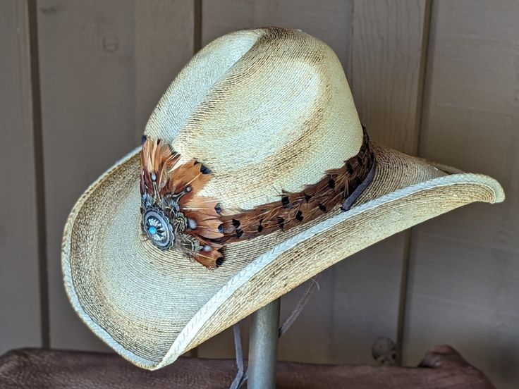 This is the perfect hat for rocking out to your favorite band, touring Nashville, or cheering on your favorite cowboy at the rodeo. Southwestern Concho Hat For Rodeo, Southwestern Style Concho Hat For Rodeo, Western Style Concho Hats For Country Events, Western Straw Hat For Kentucky Derby, Western Hats With Feathers For Ranch, Western Ranch Hats With Feathers, Southwestern Straw Hat With Short Brim For Country Events, Southwestern Straw Hat With Flat Brim For Western-themed Events, Western Summer Hats With Feathers