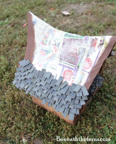 a paper mache made to look like an airplane with newspaper pages on the wings